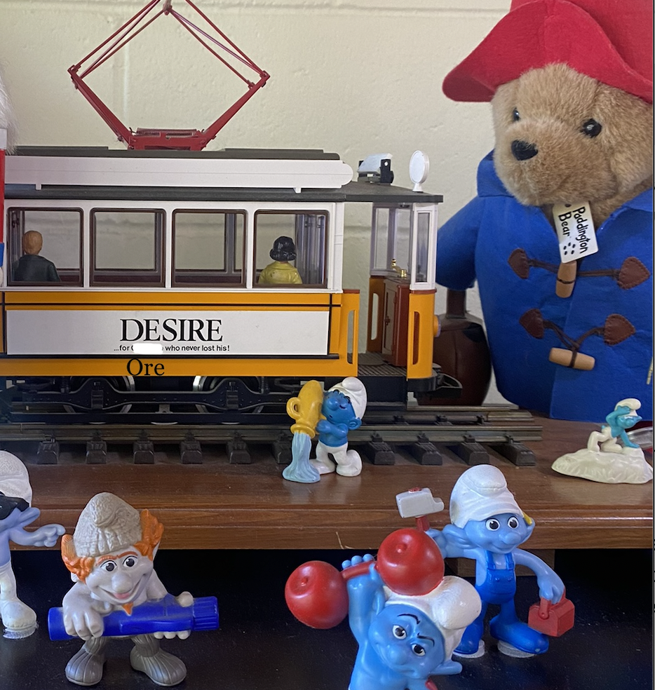 a toy train setup with smurfs, that train has text written on it "Desire, for Ore who never lost his"
